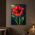 A large red amaryllis bloom with golden pollen-tipped stamens rises between two glossy green leaves against a deep blue background.; frame shown for styling only