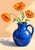 Three orange poppies with green stems in a cobalt-blue pitcher, lit by a diagonal wedge of afternoon sun.