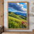 Sunlit alpine meadow with foreground grasses and colorful wildflowers beneath a sweeping blue-gray cloud and distant mountain ridges.; frame shown for styling only