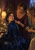 Three adult women gather around a seated bride in a deep blue gown as one fastens her collar clasp and another holds white blossoms.