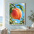 Close-up of a ripe peach attached to a branch, framed by green leaves, with a droplet hanging from its tip against a blue sky.; frame shown for styling only