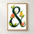 A large dark-green ampersand entwined with green leaves and three coral and yellow flowers on a warm-white background.; frame shown for styling only