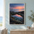 Reflective tidepool among dark coastal rocks at dawn, with coral-pink sky, calm sea, and sparse grasses.; frame shown for styling only
