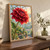 Large ruby-red dahlia with dew highlights in a sunlit greenhouse, with broad leaves, glass panes, benches, and potted plants.; frame shown for styling only