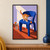 Striped ginger cat standing on a cobalt-blue chair and looking toward an orange marigold, with a glass of cut flowers on the floor.; frame shown for styling only