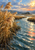 Golden reeds beside a winding channel with coral reflections, distant hills, trees, and a low sunlit sky.