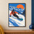 Adult snowboarder in coral outerwear carving on a teal board through powder, with blue mountains, firs, and a large orange sun.; frame shown for styling only
