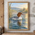 Russet-headed waterbird gliding across a river with reeds at left and a softly lit wooded bank behind.; frame shown for styling only