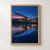Curved blue-glass pavilion with warm lit windows reflected in a river beneath a rose-pink dusk horizon.; frame shown for styling only