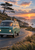 Sea-green camper van with roof luggage on a coastal road at sunrise, with ocean and a leaning pine behind it.