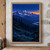 A pale moon above a blue alpine range, with dark fir-covered slopes, foreground branches and an apricot sunset strip.; frame shown for styling only