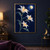 Three pale star-shaped flowers with orange centers and curved leaves branch beneath a bright round pod against deep blue.; frame shown for styling only