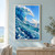 A cobalt-blue wave curls around a bright opening of sky, with reflective bubbles, white spray, and a distant horizon.; frame shown for styling only