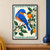 Blue-and-orange bird perched on a diagonal branch beside oranges, green leaves, and white blossoms, surrounded by a teal leaf border.; frame shown for styling only