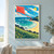 Oversized coral-red diamond kite and curling tail above a crescent beach, turquoise sea, tiny figures, and grassy coastal bluffs.; frame shown for styling only