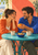 Two smiling adults share a whole orange across a turquoise café table with ceramic cups, citrus wedges, foliage, and a coastal view.