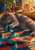 Smoke-gray cat reaching toward a teal ribbon on a patchwork rug as a ginger kitten watches from a sunlit cushion.