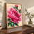 Large layered pink peony with two upright buds and broad green leaves against a pale apricot background with a faint blue halo.; frame shown for styling only