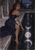 A red-haired fantasy moon goddess in a dark blue gown reaches toward lunar reflections in a pool beside carved stone pillars.