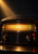 Dark tabletop radio with a glowing amber tuning dial, green needle, red indicator light, and three knobs in a warm beam.