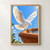 White dove with raised wings descending toward the rim of a terracotta fountain with water jets and green leaves against a blue sky.; frame shown for styling only