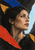 Adult woman in a right-facing profile, looking toward pale-blue light amid bold torn-looking black, blue, red, and ochre shapes.