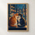 Two cats sit close together on a windowsill, touching faces before a rain-streaked window with blurred city lights.; frame shown for styling only