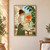 Adult woman in profile holding an orange poppy-like flower above a clear glass vase in a sunny room with an arched window and leafy plant.; frame shown for styling only