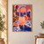 A pink grapefruit cocktail with citrus wedges sits on patterned terrace tiles before arched openings framing a sunset sea.; frame shown for styling only