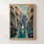 Cream-sailed ochre boat crossing a reflective teal gorge between towering tree-covered cliffs beneath coral-streaked clouds.; frame shown for styling only
