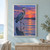 Blue-gray heron standing in shallow water with a reflection beneath a coral-violet sunset.; frame shown for styling only