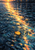 Gold-orange leaf floating near the lower center of dark blue rain-rippled water beneath a diagonal sunset reflection.