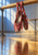 Two burgundy-red ballet slippers hanging by their ribbons from a wooden barre, reflected on a studio floor under blue and warm light.