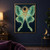 A front-facing jade-green moth with long trailing wing tails beneath a dark moon with a narrow golden rim.; frame shown for styling only