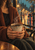 A seated person in a rust knit cardigan warming both hands around a steaming ceramic coffee mug beside a rainy city window.