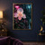 Large pale pink orchid with visible petal veins and water droplets in a dark, rain-streaked greenhouse beneath a hanging fuchsia lamp.; frame shown for styling only