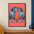 Two blue-gray, cream-dappled horses face nose to nose around an orange marigold on a coral-pink background.; frame shown for styling only