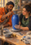 Two adult ceramic artists work around a cobalt-blue vessel on a pottery wheel, with a small tool near the rim and studio materials on the table.