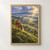 Russet fox looking back from a grassy ridge above a misty flowering orchard as golden sunbeams break through clouds.; frame shown for styling only