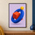 A tilted blue ring interlocks with a vermilion cube, with a yellow sphere above on a pale-lilac background.; frame shown for styling only