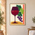 Stylized plum wineglass with a garnet-red fill, angular green leaves, six purple grapes, coral bar and ochre curve on ivory.; frame shown for styling only