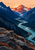 Teal river winding through a mountain valley toward a rust-red peak, framed by dark blue ridges and angular foreground rocks.