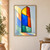 Tall asymmetrical window with six colored panes casting angular colored light on a pale wall and floor.; frame shown for styling only