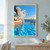 White pelican with a fish at its bill beside an infinity pool, watched by two swimmers, with boats and a coastal skyline at sunset.; frame shown for styling only