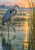 Blue-gray heron lifting one leg above circular ripples in marsh water at sunrise, with reeds and a distant tree line.