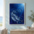 Three large silver-blue mackerel lead a school through deep indigo water toward light entering from the upper right.; frame shown for styling only