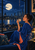 Woman in a cobalt robe raising a decorated teacup beside a large moon and illuminated waterfront city window.