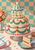 Decorated pavilion-shaped cake with teal icing, coral rosettes, candles and a slice on a blue plate against a turquoise-and-apricot checkerboard wall.
