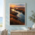 A winding reflective channel cuts through rust-colored salt-marsh reeds and dark mudflats beneath an apricot sunrise.; frame shown for styling only