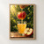 A red-and-gold apple hangs above a glass receiving a stream of juice, beside a cut seeded apple half against leafy greenery.; frame shown for styling only
